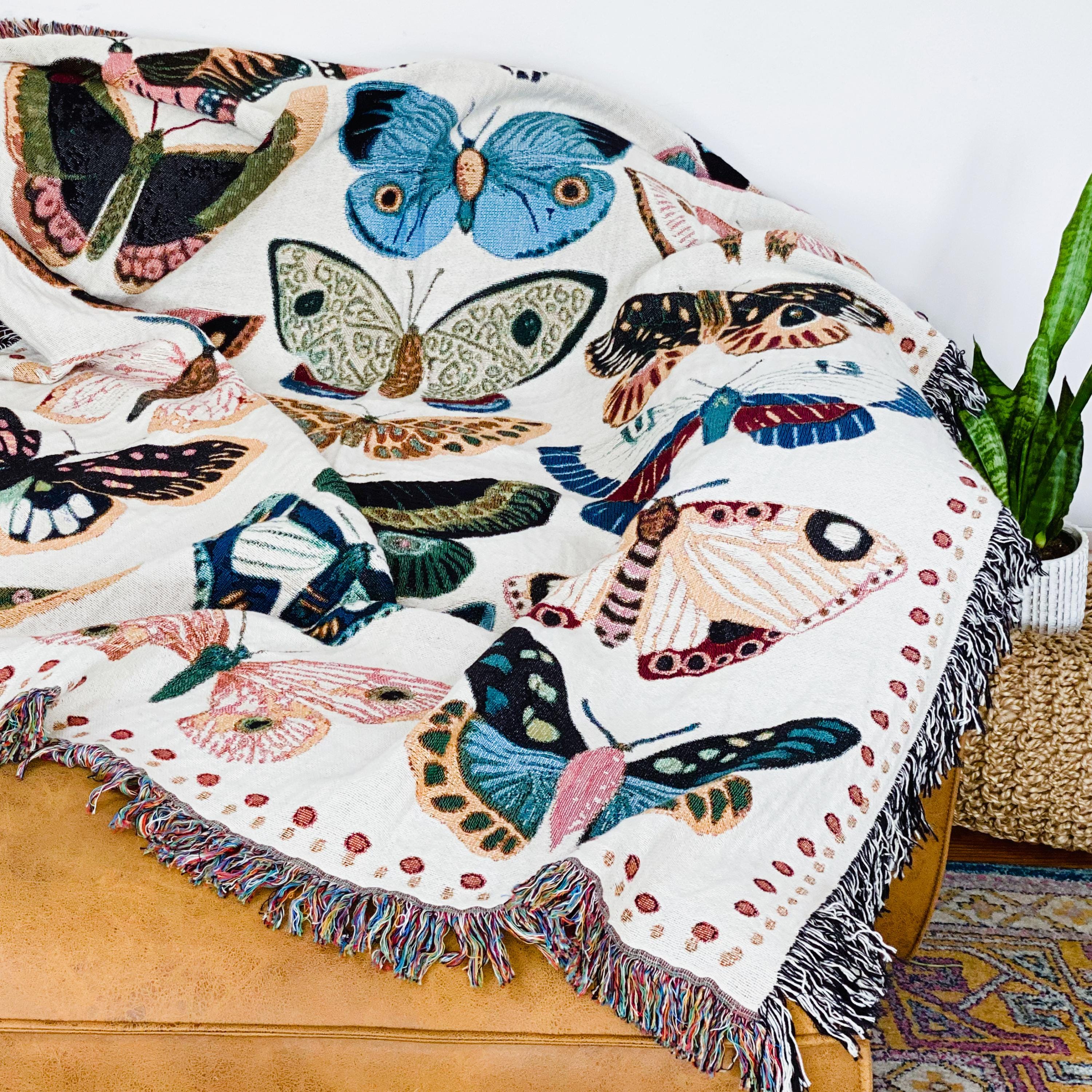Cozy woven throw blanket with vibrant hand-illustrated butterflies. Brings joyful colors and charm to nurseries, dorms, and reading nooks.